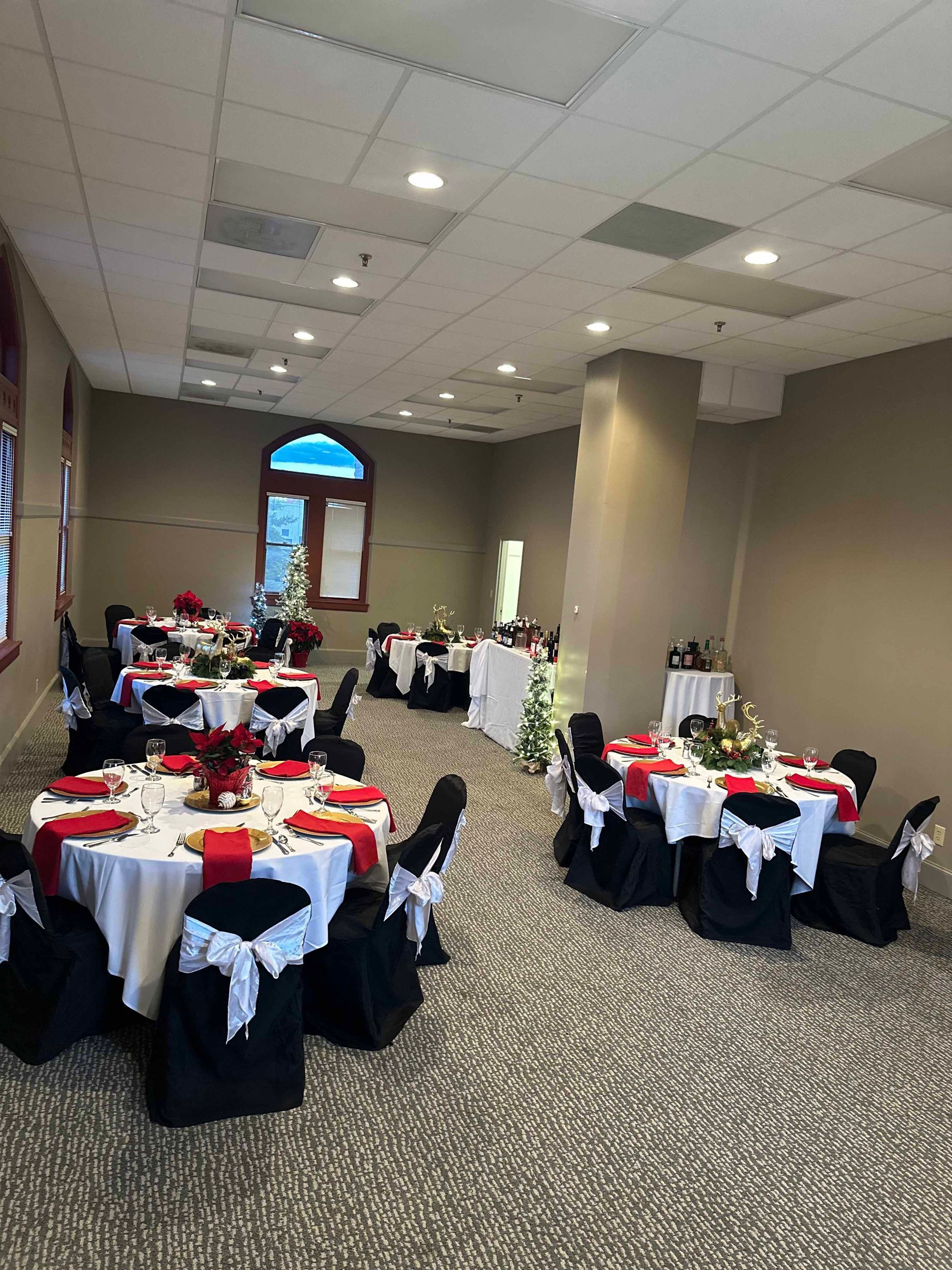 A large room with tables and chairs set up for a wedding reception.