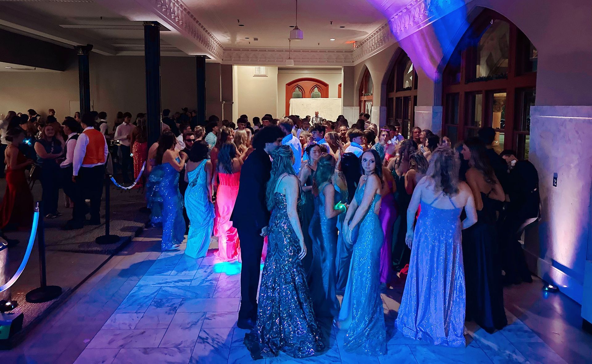 A large group of people are dancing in a large room.