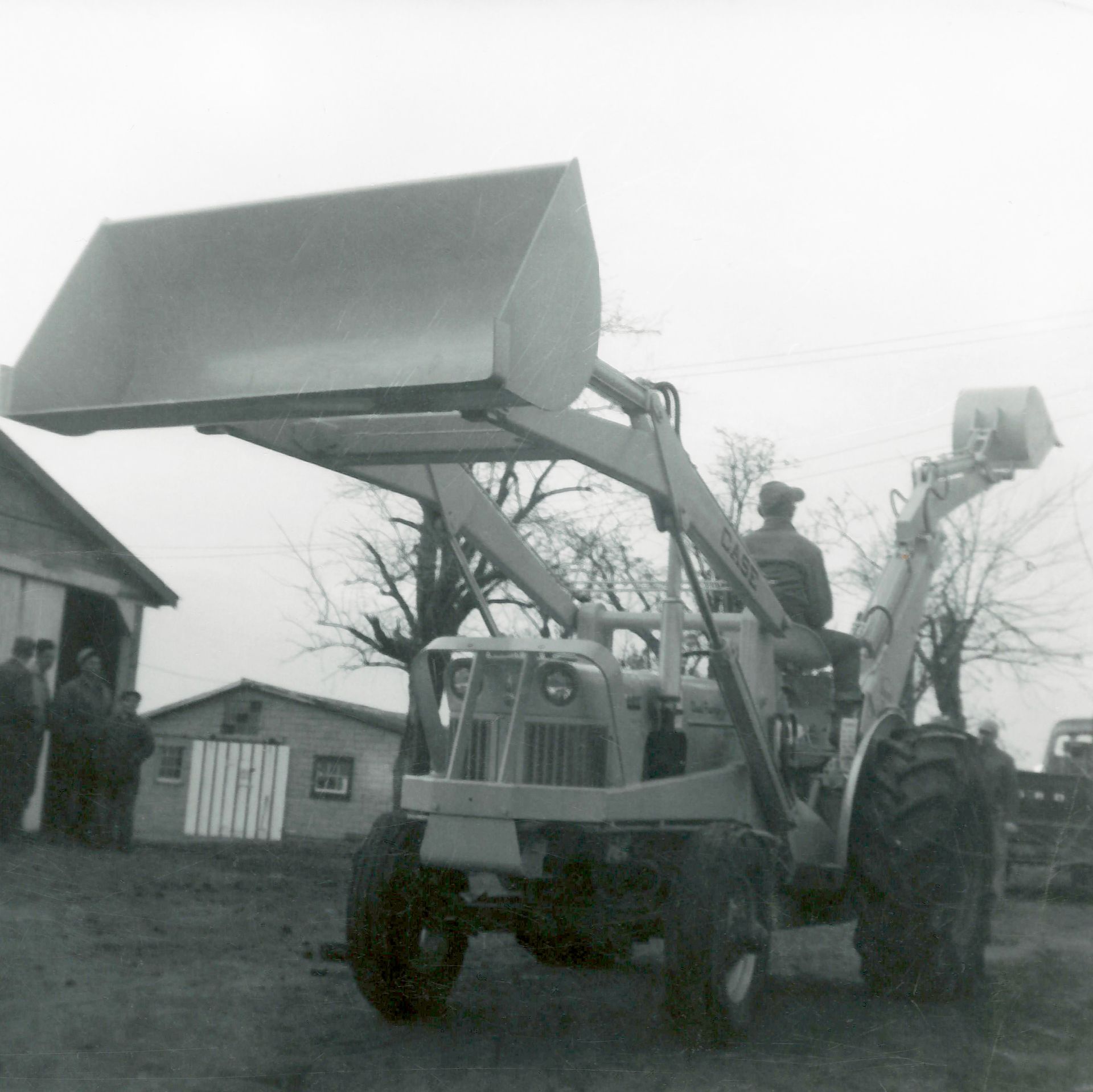 A black and white photo of a man driving a tractor