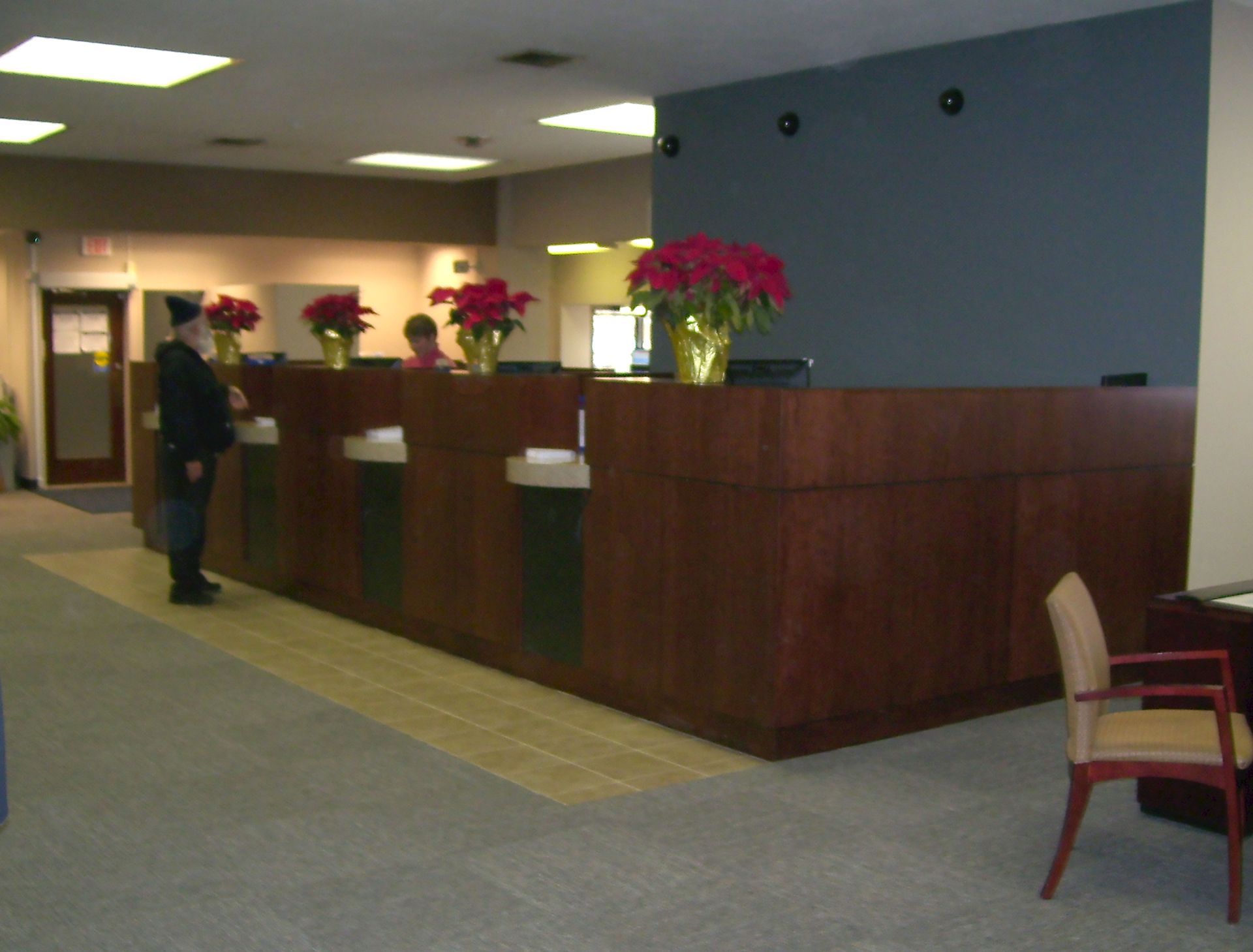 A man stands at a counter in an office with flowers on it