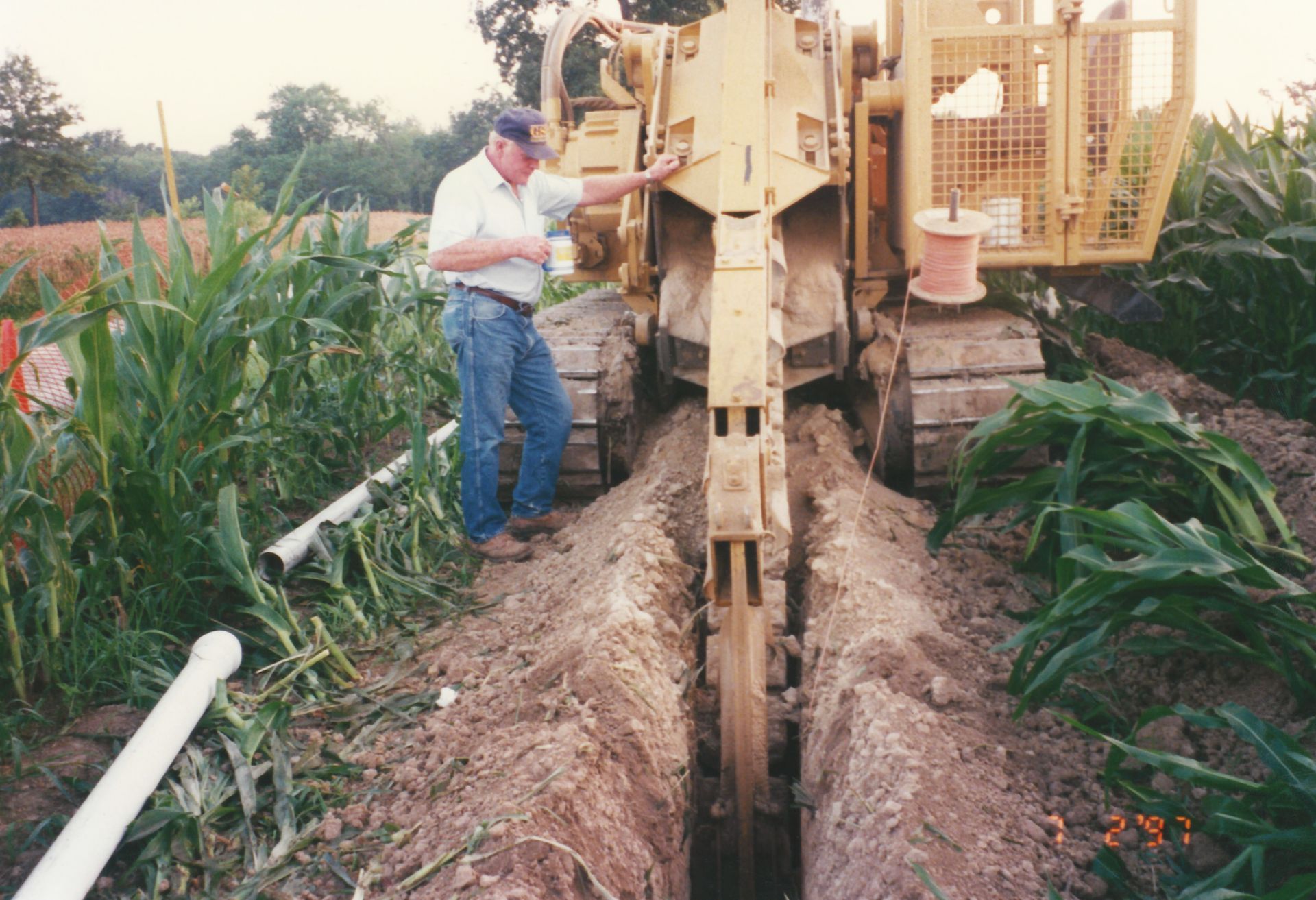 A man is standing next to a bulldozer in a field