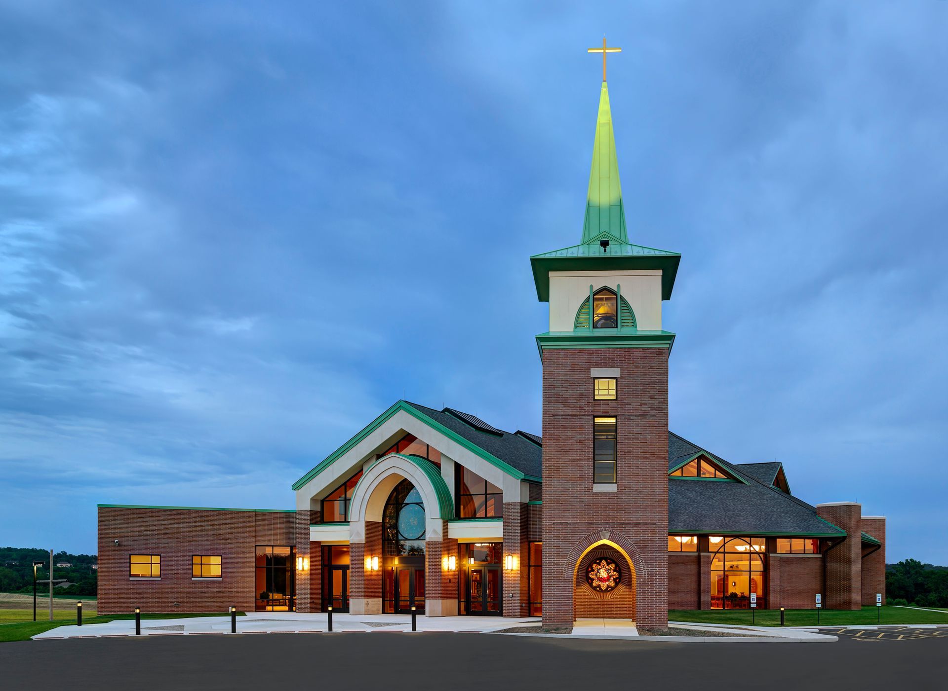 A church with a green steeple and a cross on top