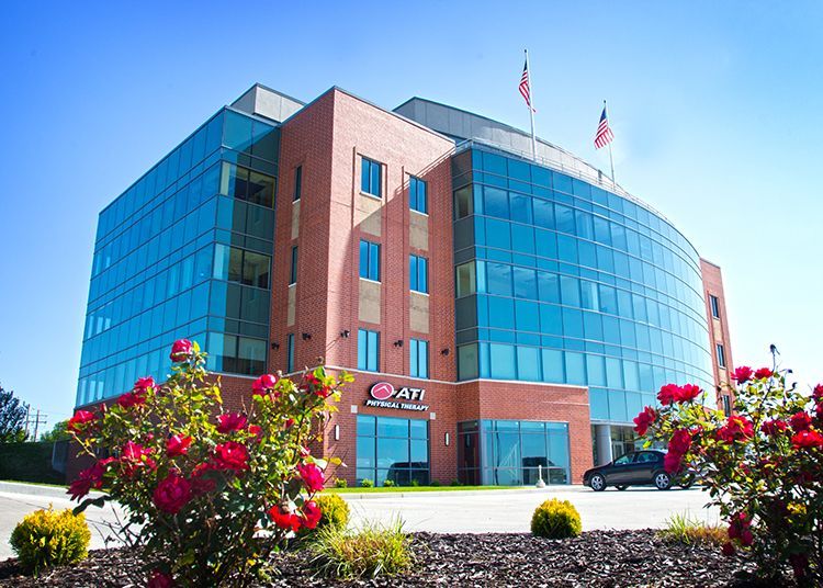 A large building with a lot of windows and flowers in front of it