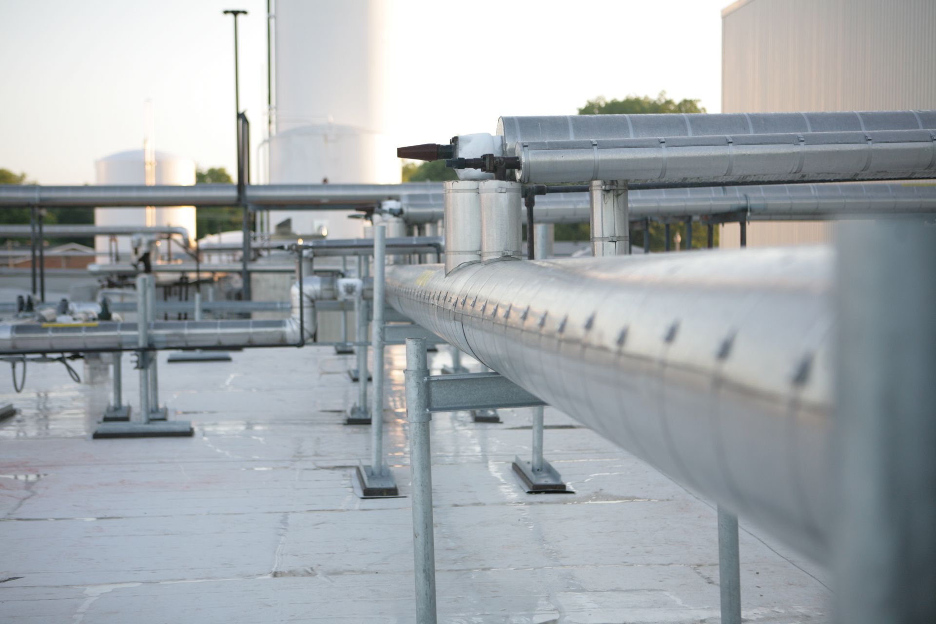 A bunch of pipes are lined up on the roof of a building.