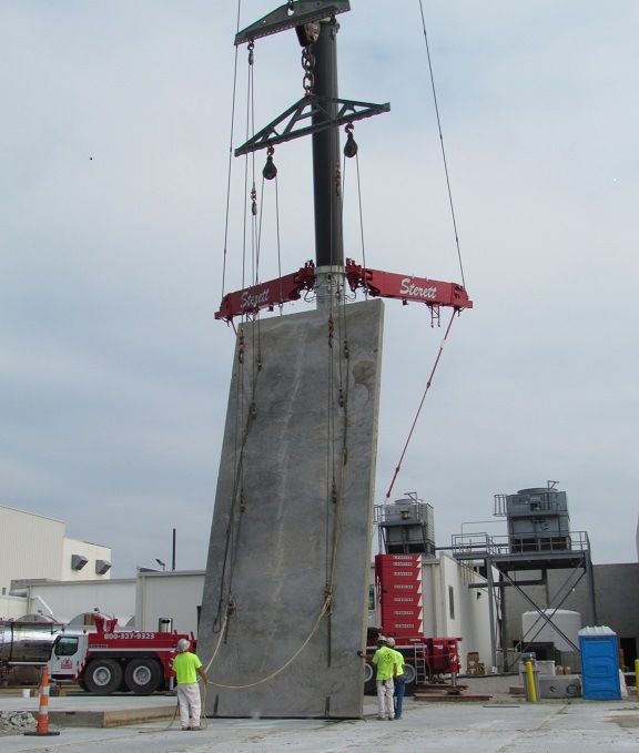 A large piece of concrete is being lifted by a crane that says snap on it