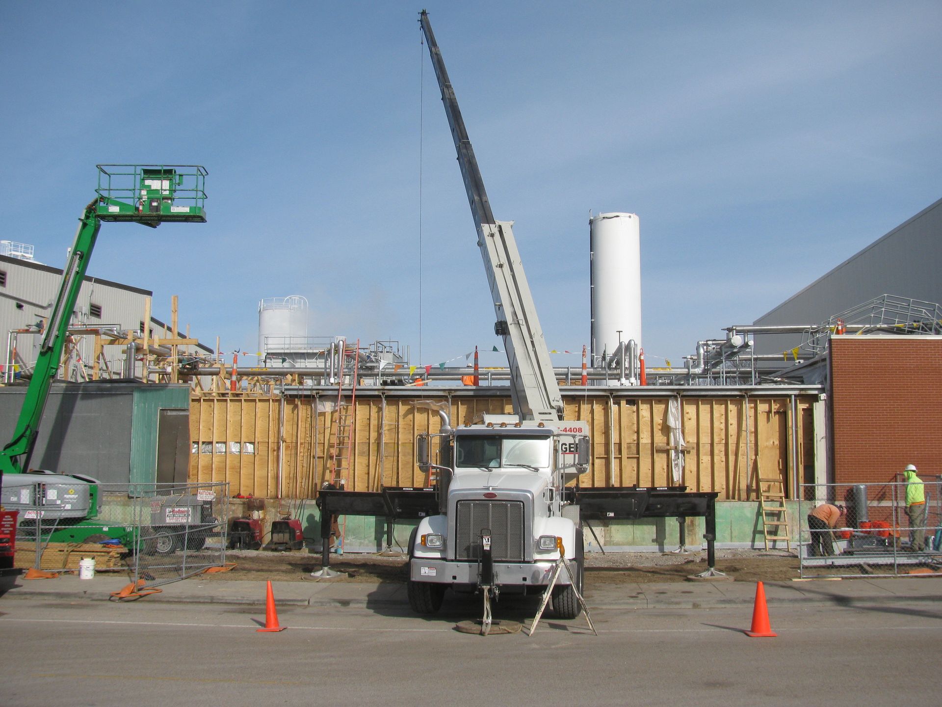 A large white truck is parked in front of a building under construction
