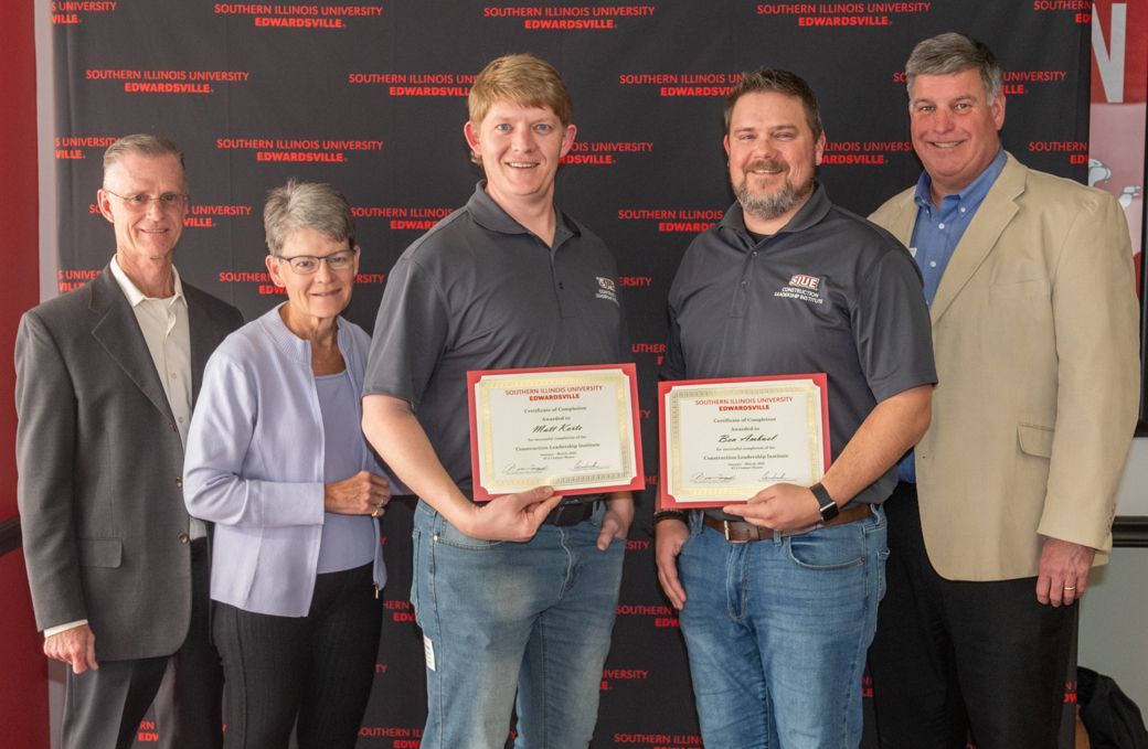 A group of people are standing next to each other holding certificates.