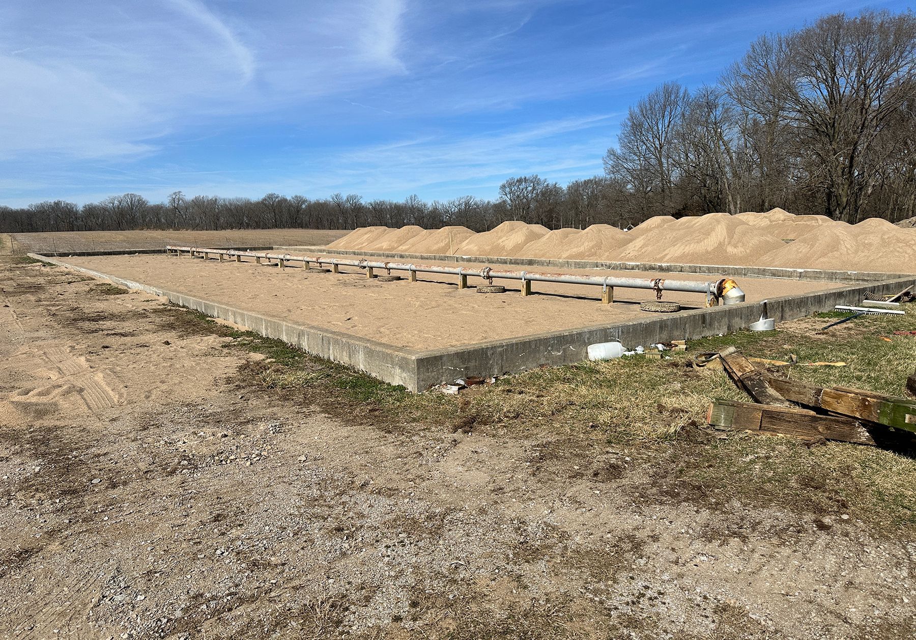 A large pile of dirt is sitting in the middle of a dirt field.
