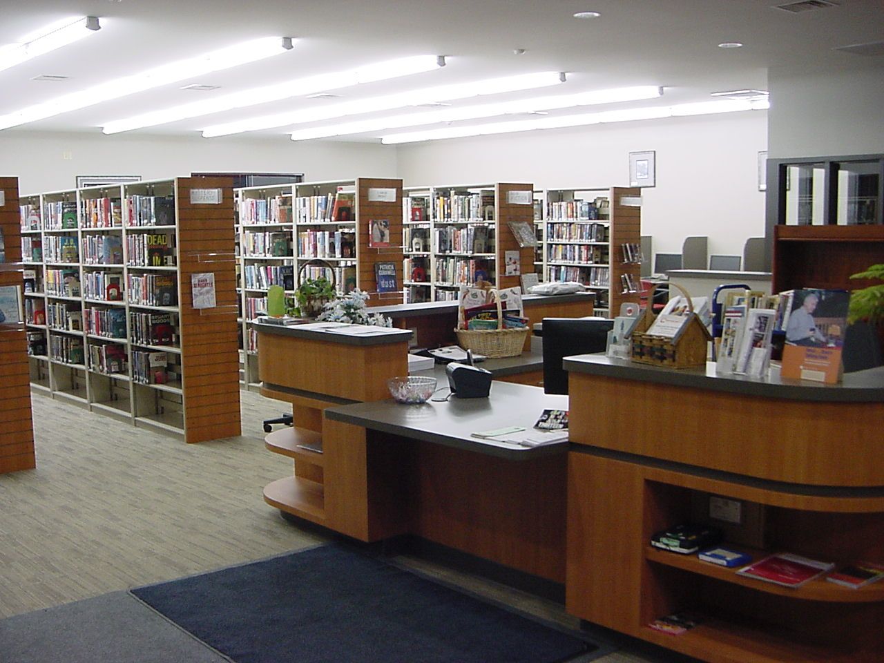 A library with lots of books on shelves and a desk