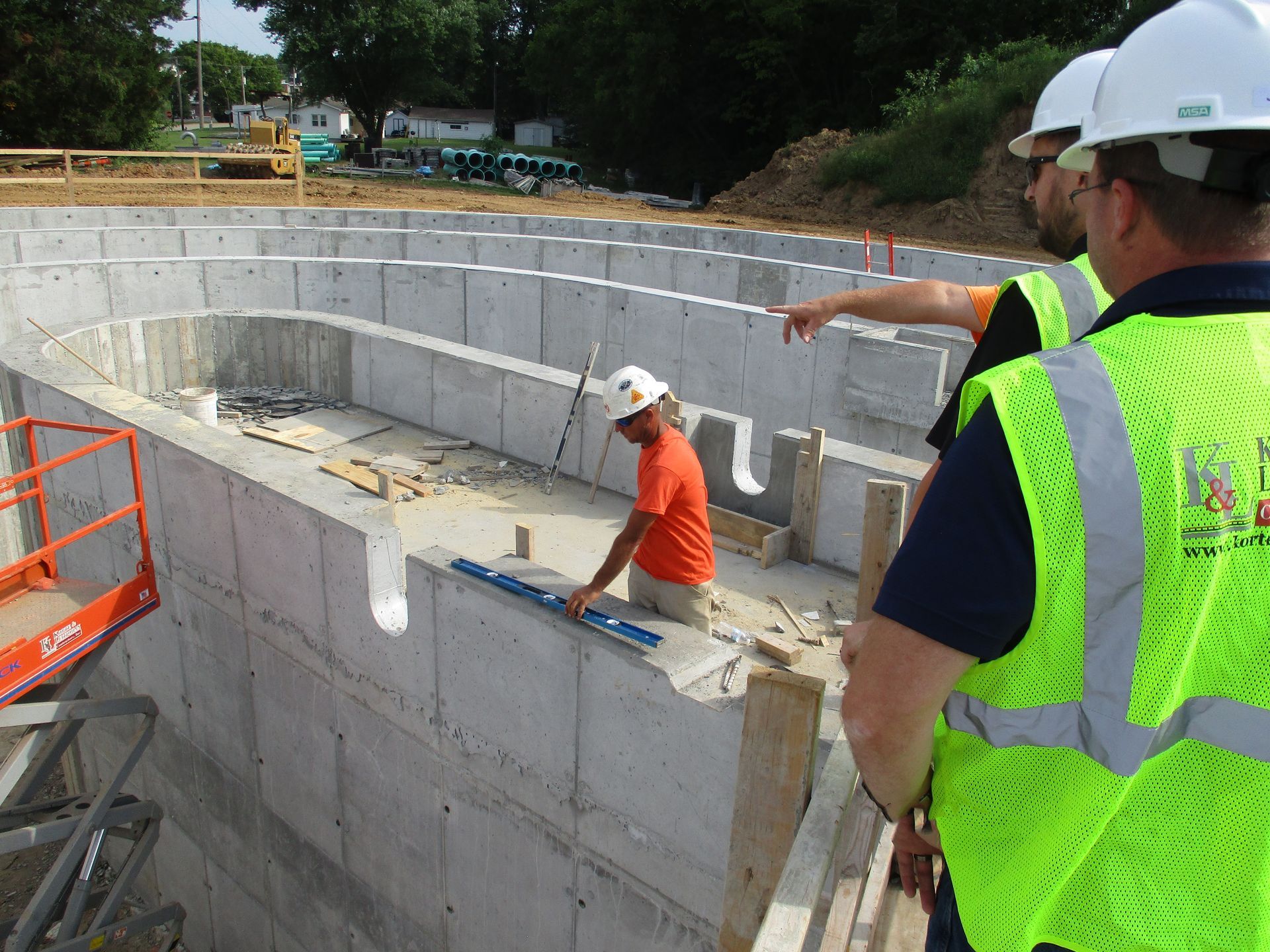 A group of construction workers are working on a concrete wall