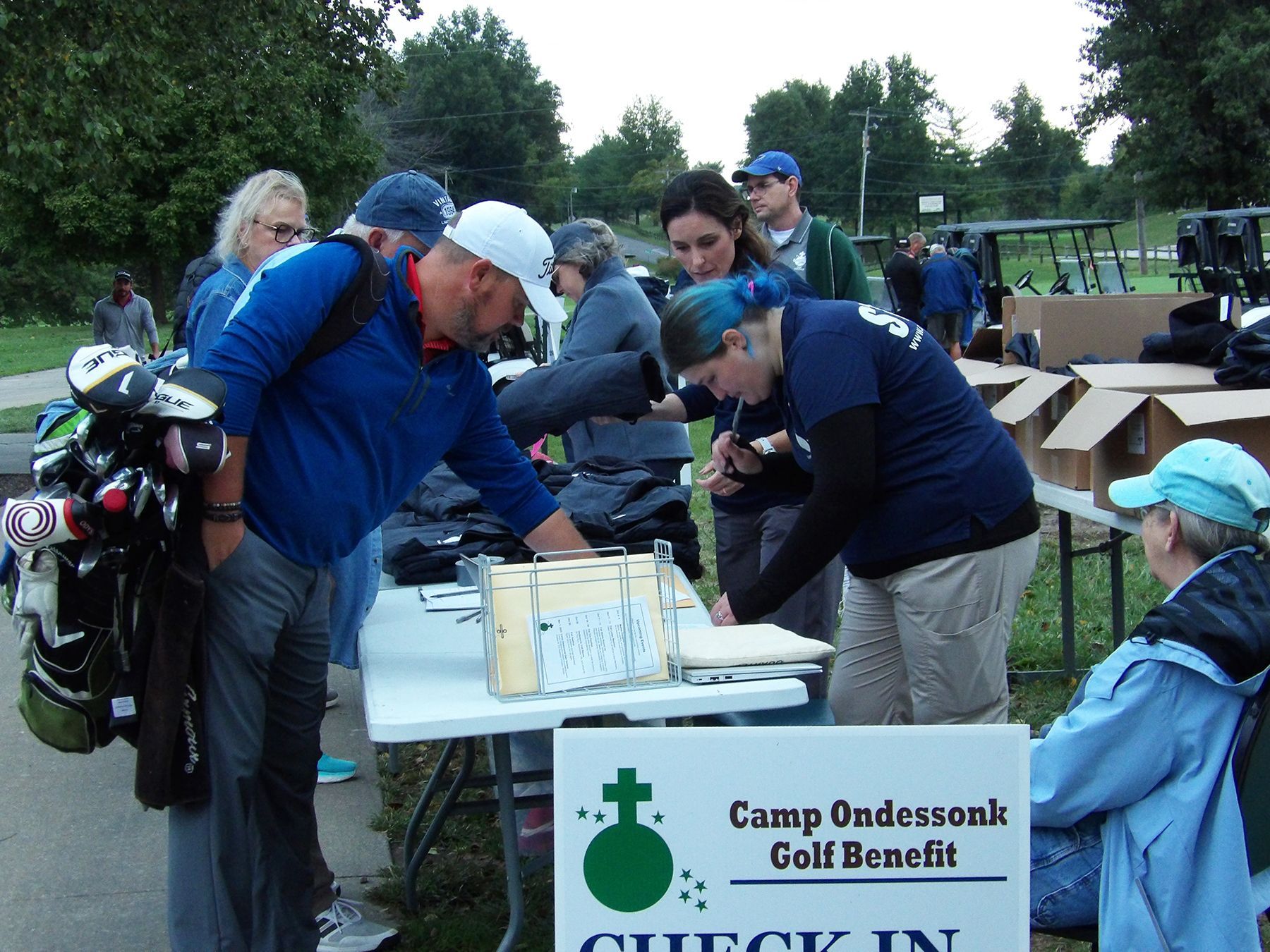 A group of people standing around a table with a sign that says check in