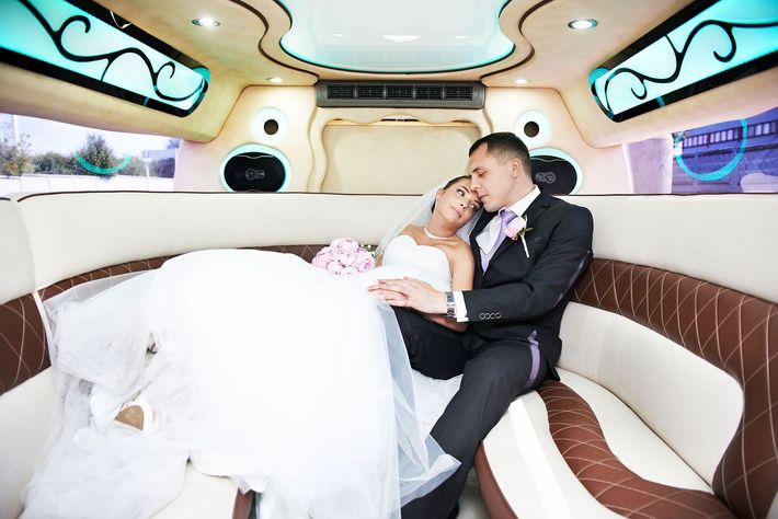 Happy bride and groom in Limousine