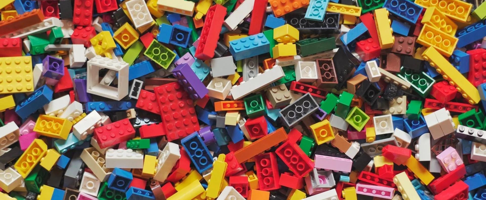 Pile of colorful LEGO bricks, including red, yellow, blue, and green pieces.