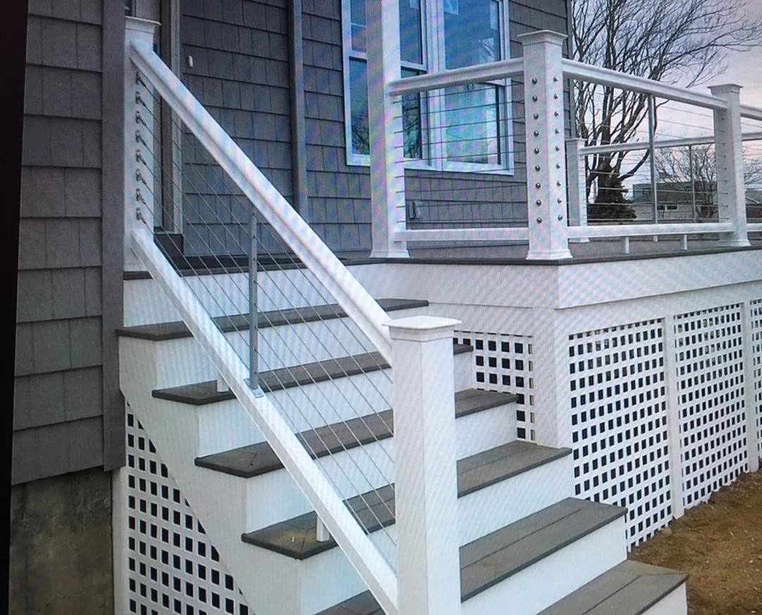 A set of stairs leading up to a deck with a white railing