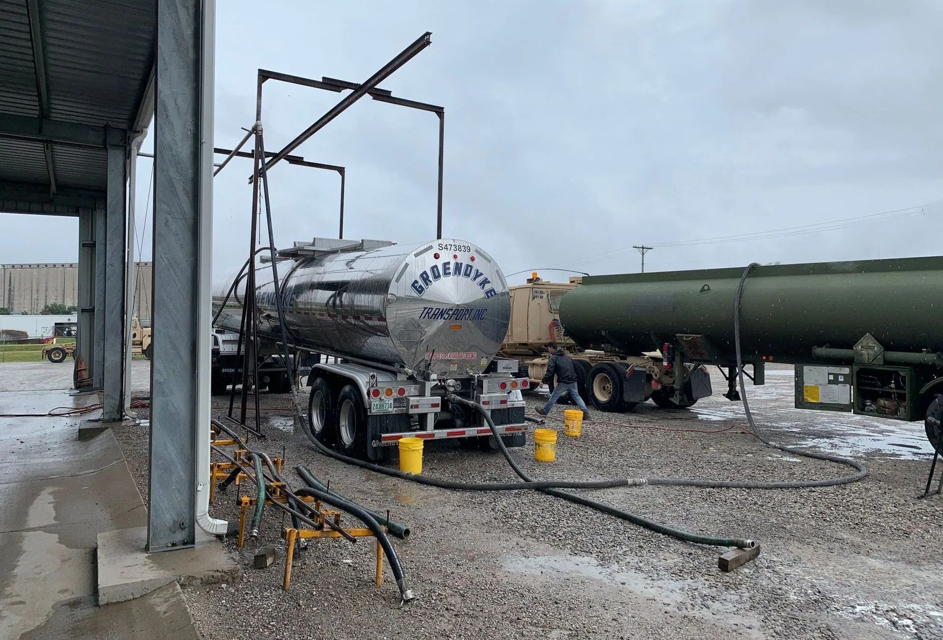 A tanker truck is being filled with gas at a gas station.