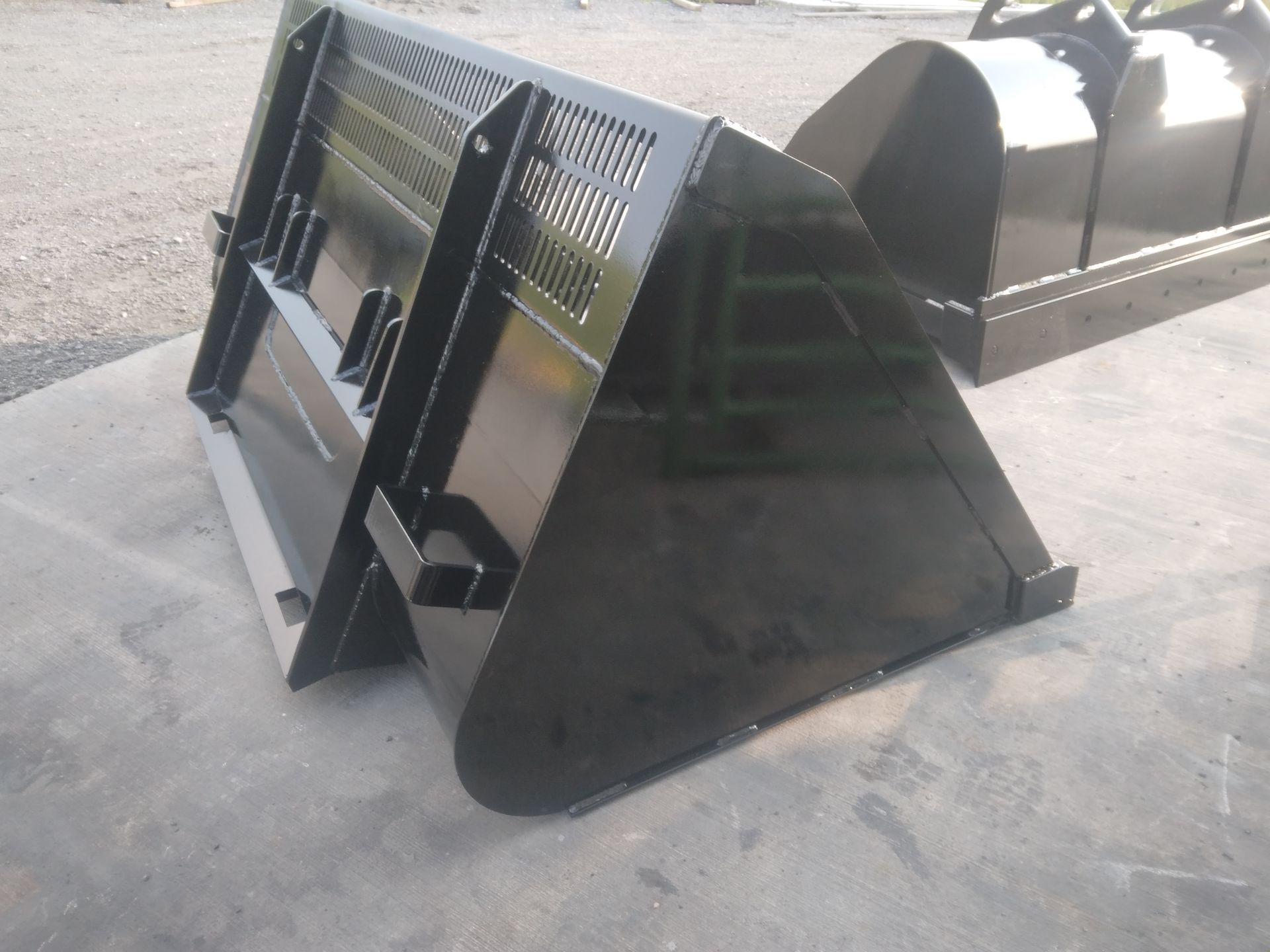 A black bucket is sitting on a concrete surface