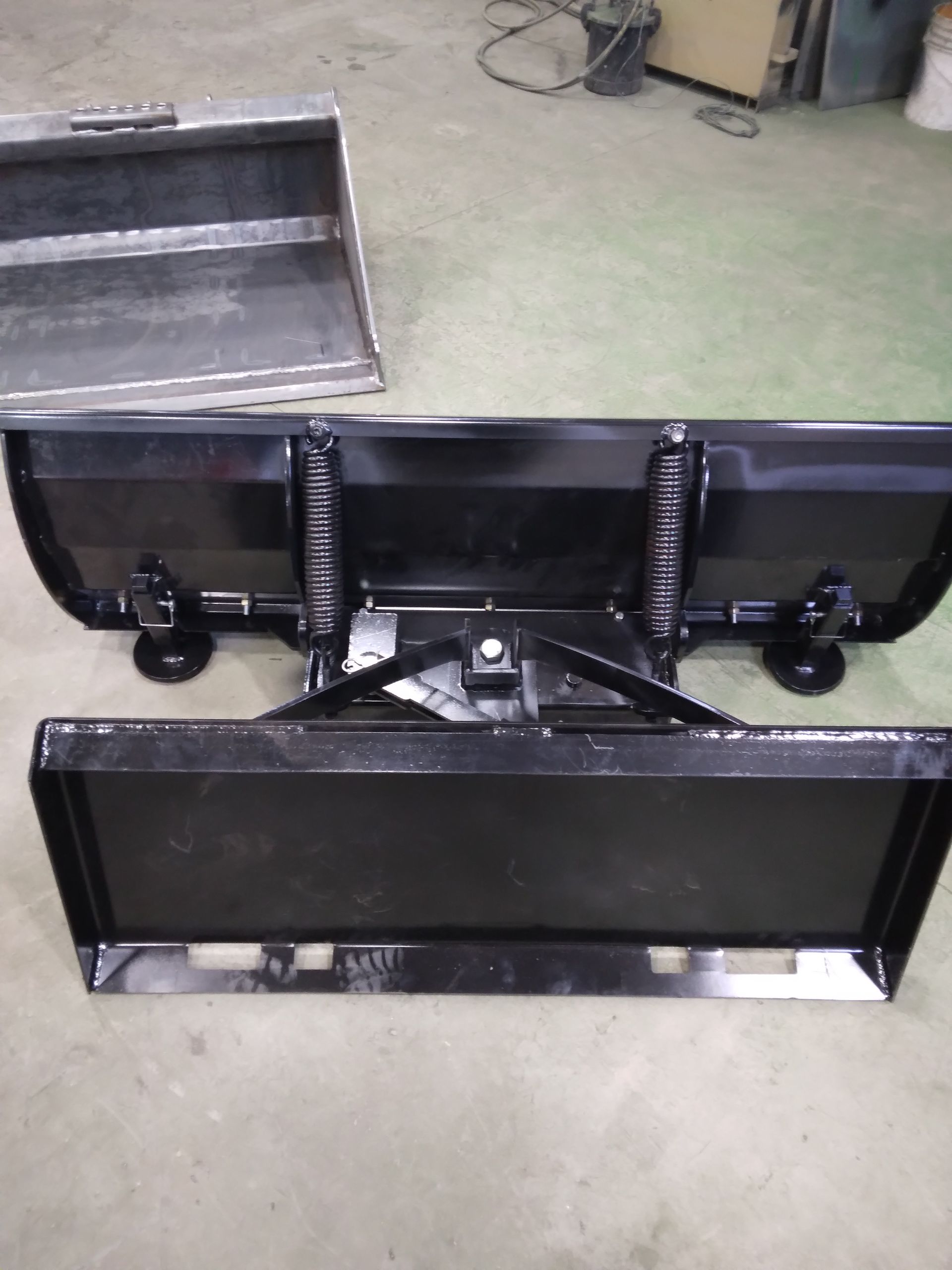 A snow plow with a bucket attached to it