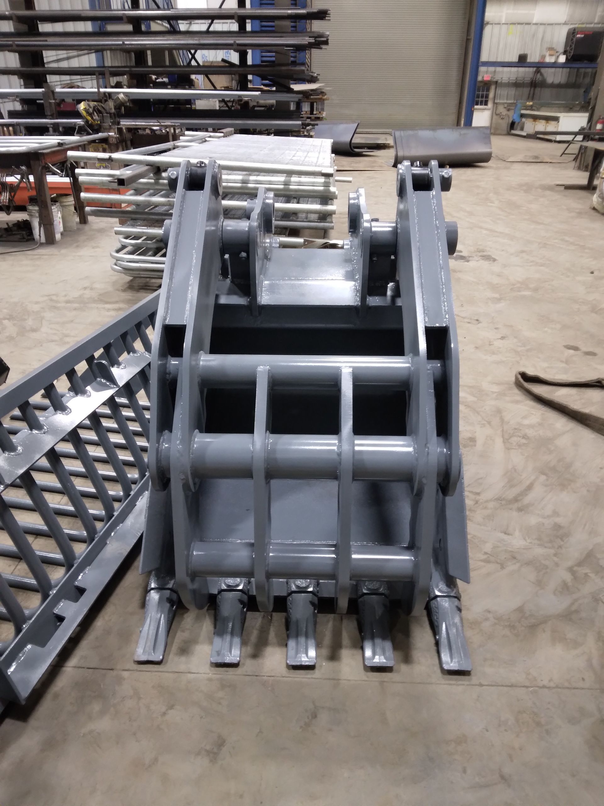 A large metal bucket is sitting on the floor in a factory.
