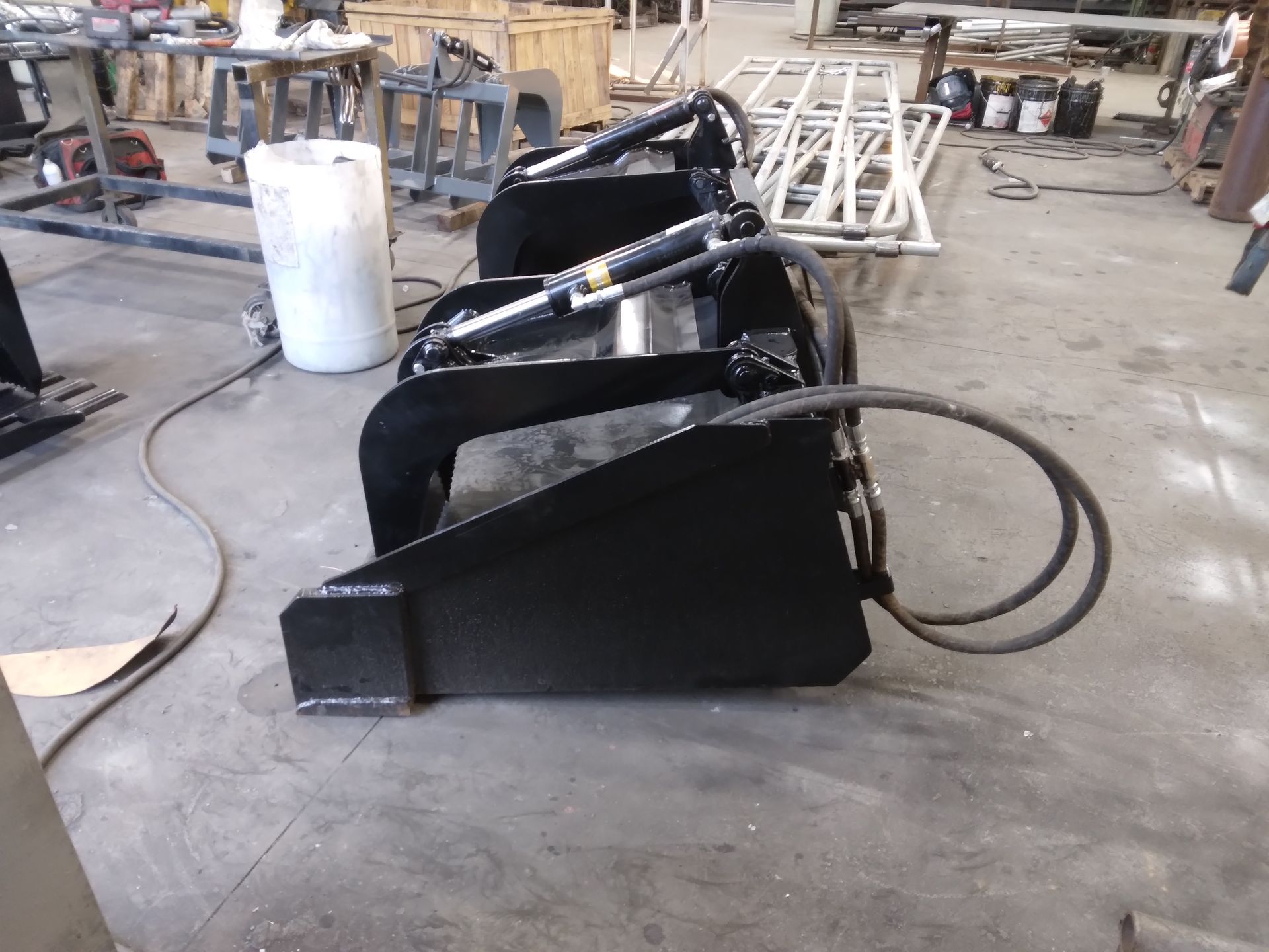 A black bucket with a hose attached to it