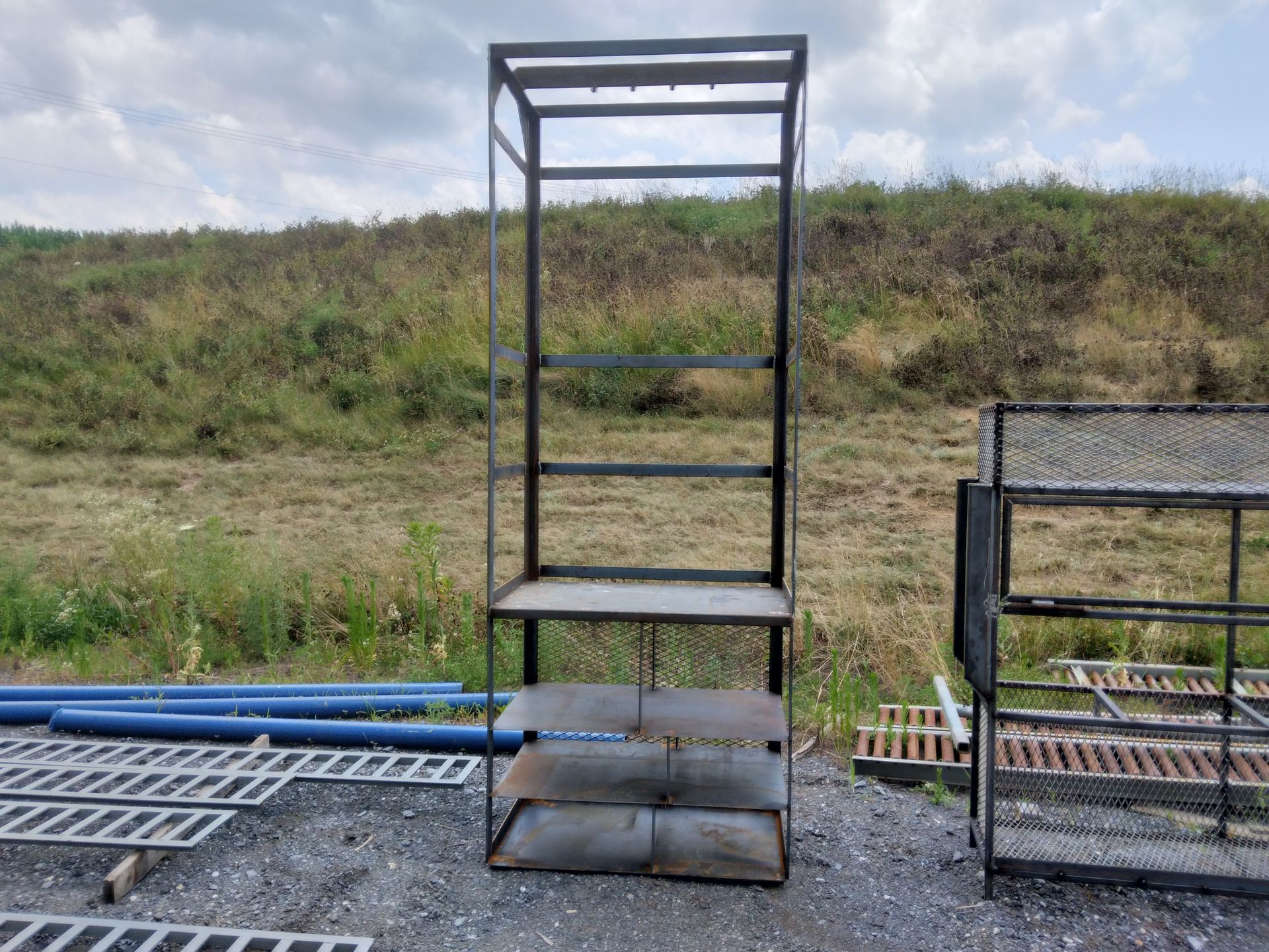 A metal shelf is sitting in the middle of a field.