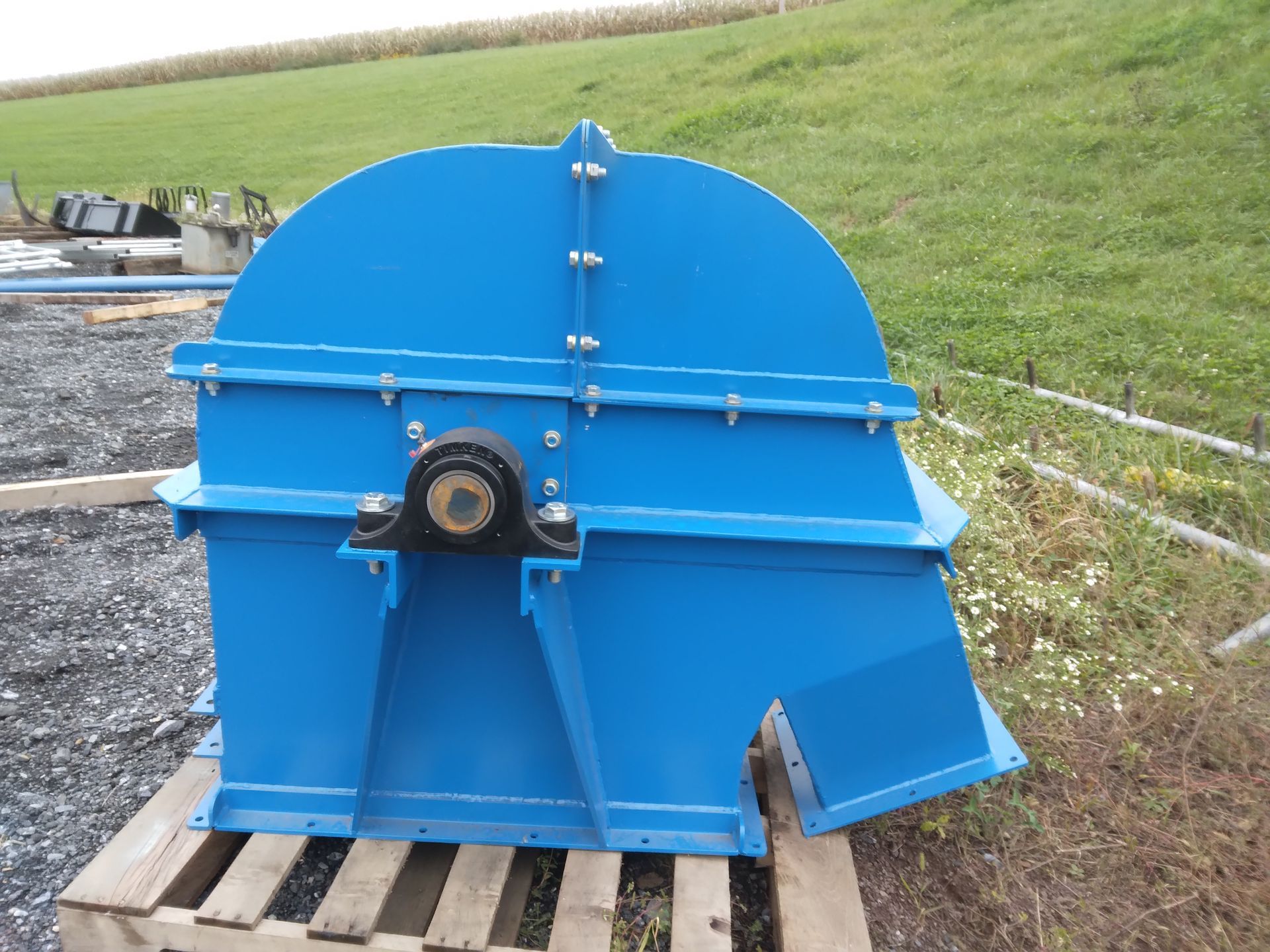 A large blue machine is sitting on a wooden pallet