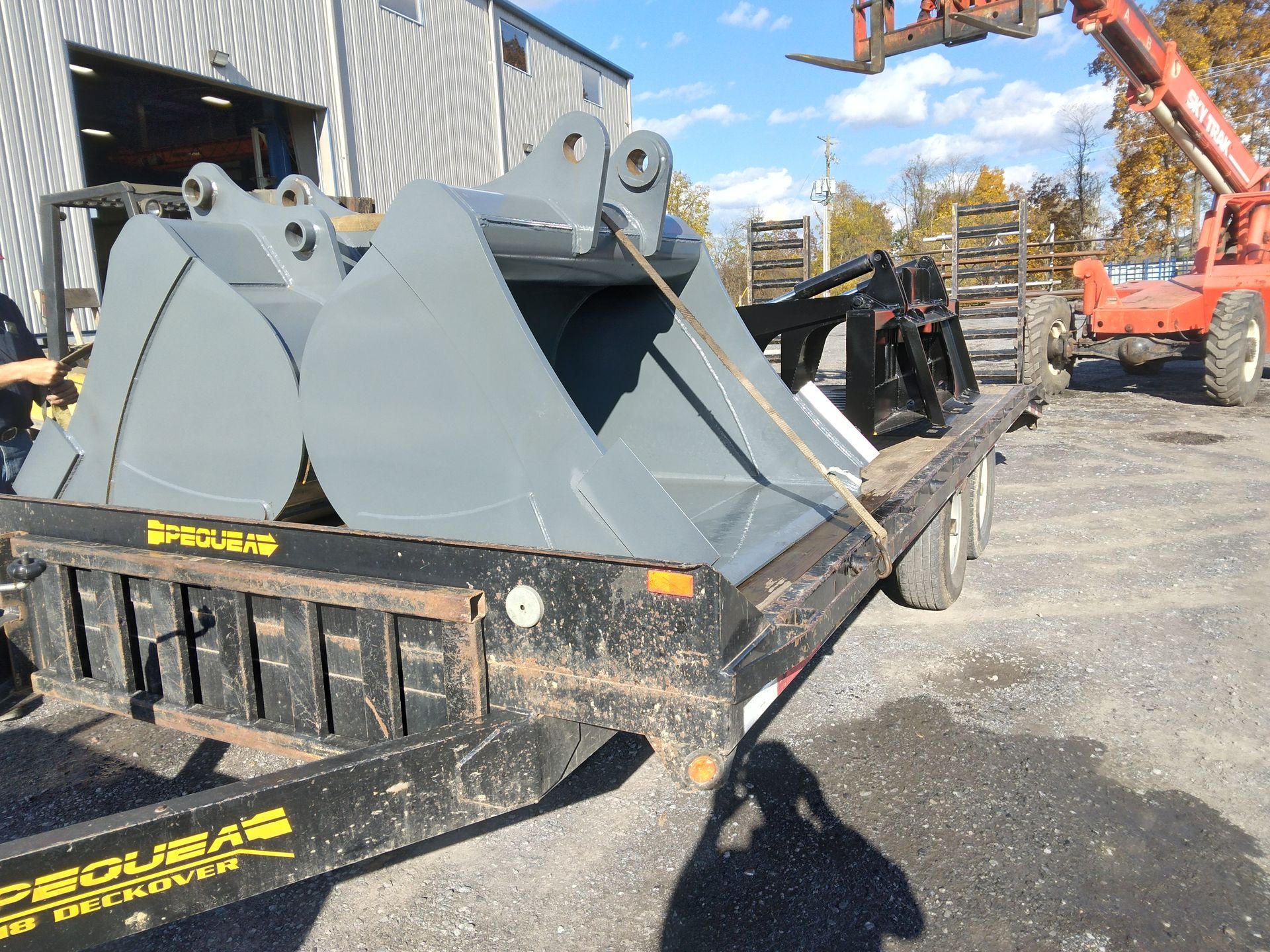 A large bucket is sitting on top of a trailer.