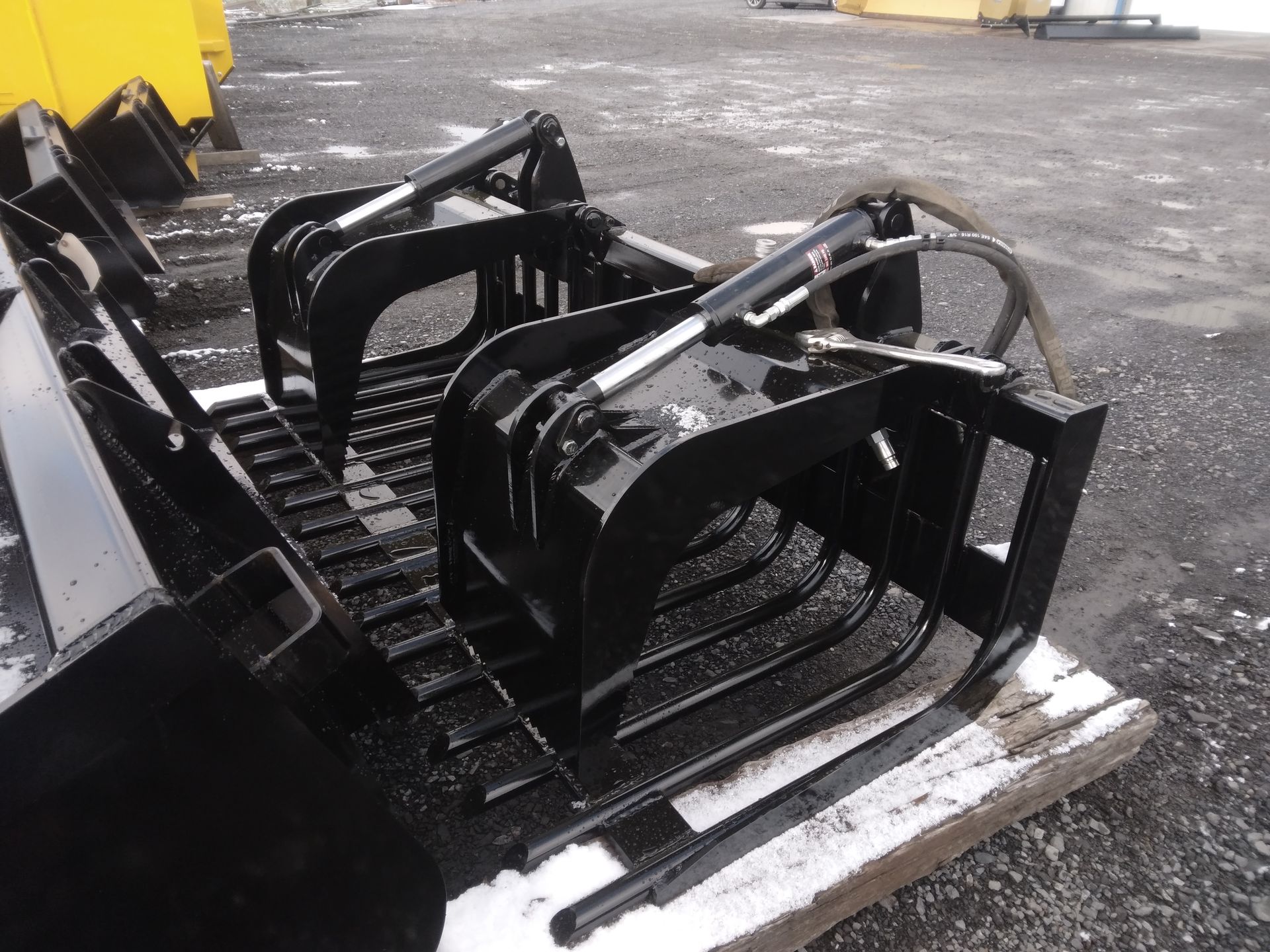 A black bucket with a pair of forks attached to it