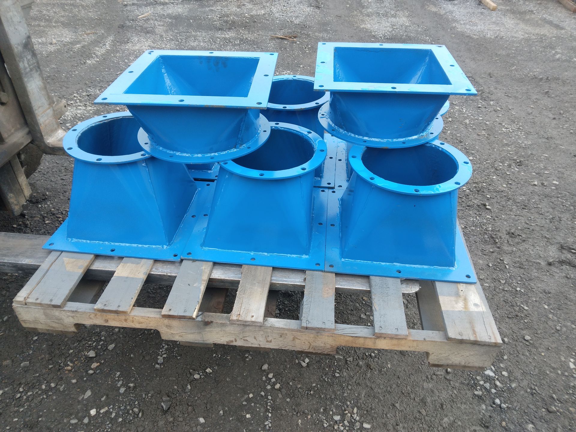 A bunch of blue pipes are sitting on a wooden pallet