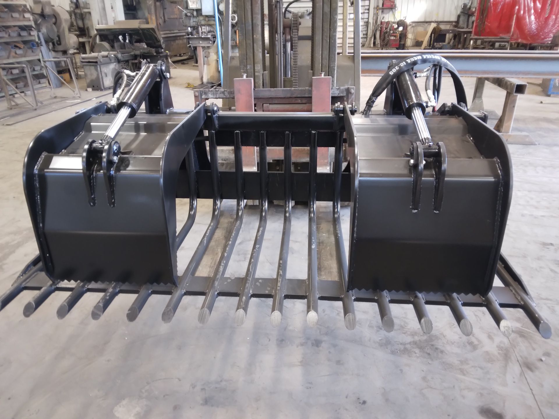 A large black bucket with a fork attached to it