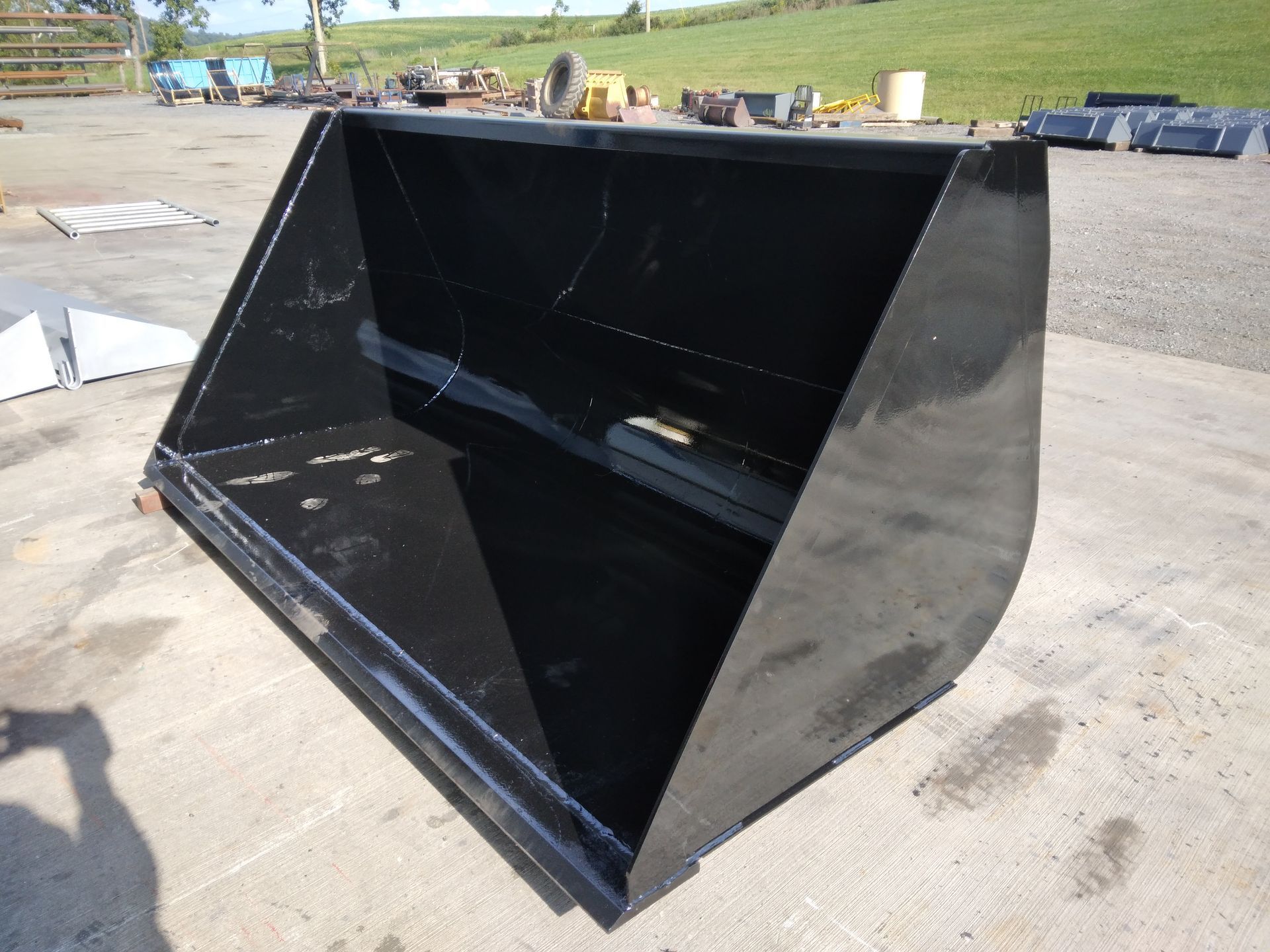 A black bucket is sitting on the ground in a parking lot