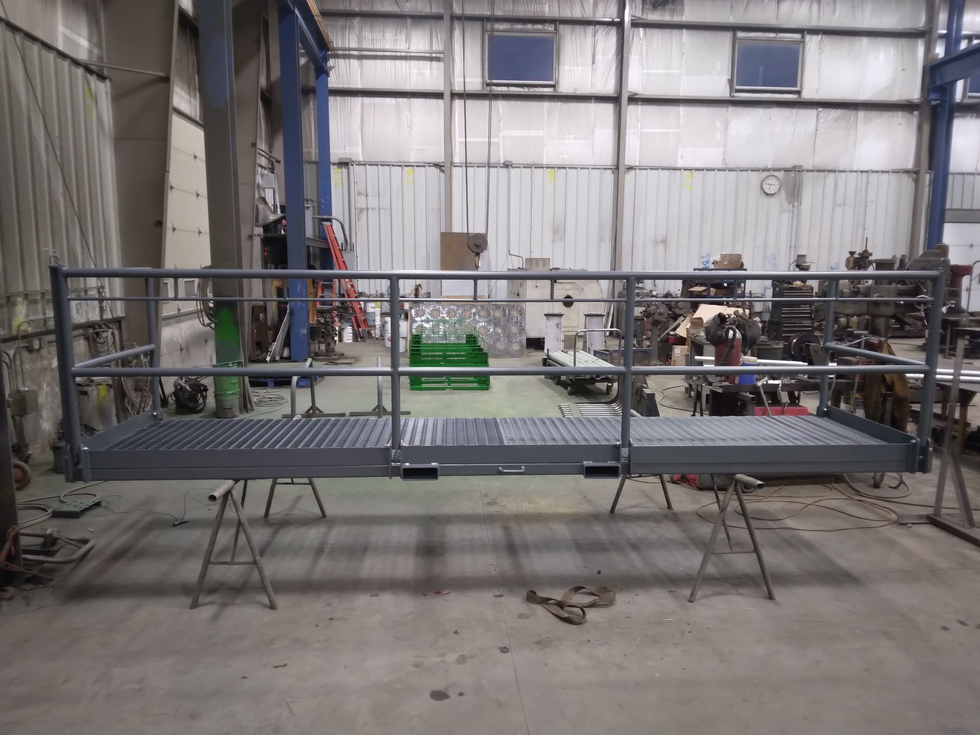 A metal platform with a railing is sitting in a warehouse.
