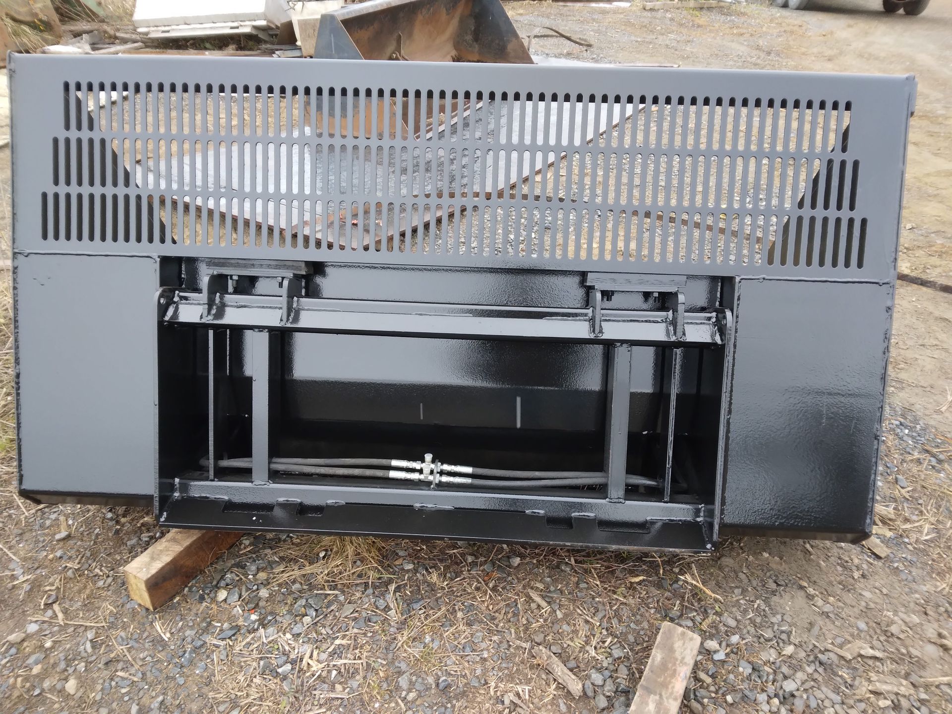 A black item is sitting on a pile of gravel