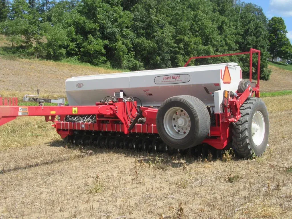 A red and white tractor is parked in a field