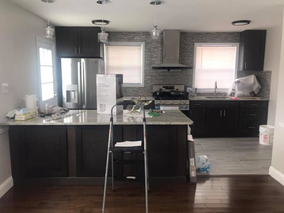 A kitchen with a ladder in the middle of it.