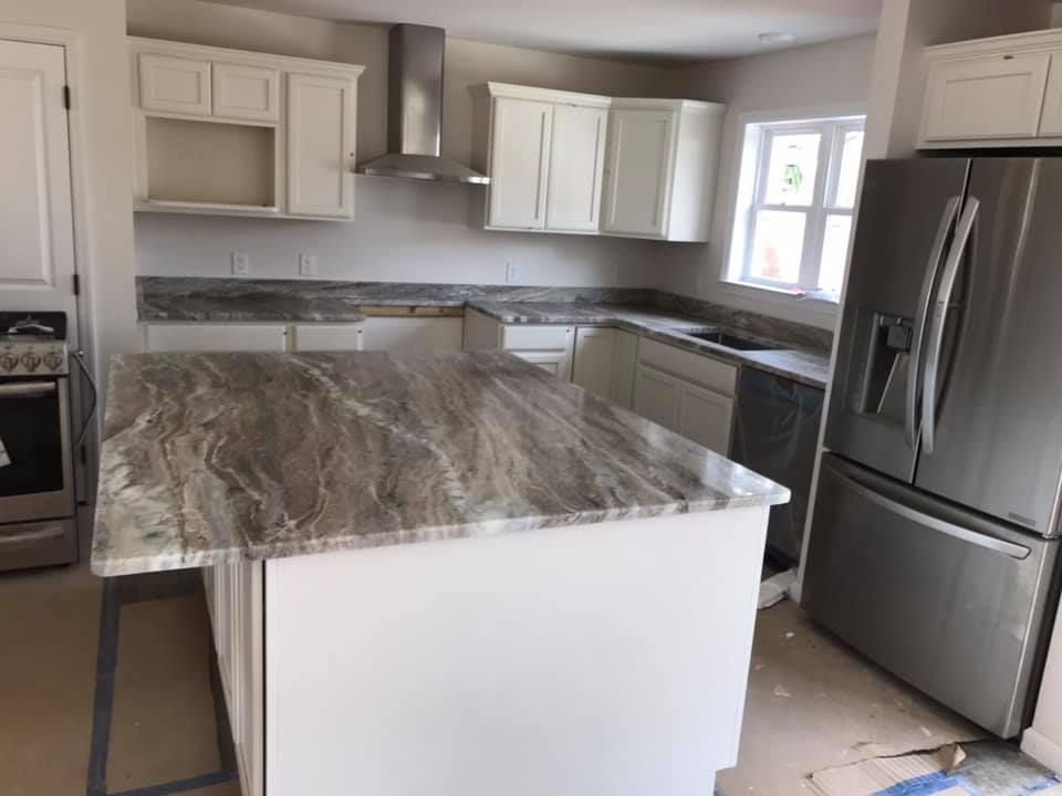 A kitchen with stainless steel appliances and granite counter tops.
