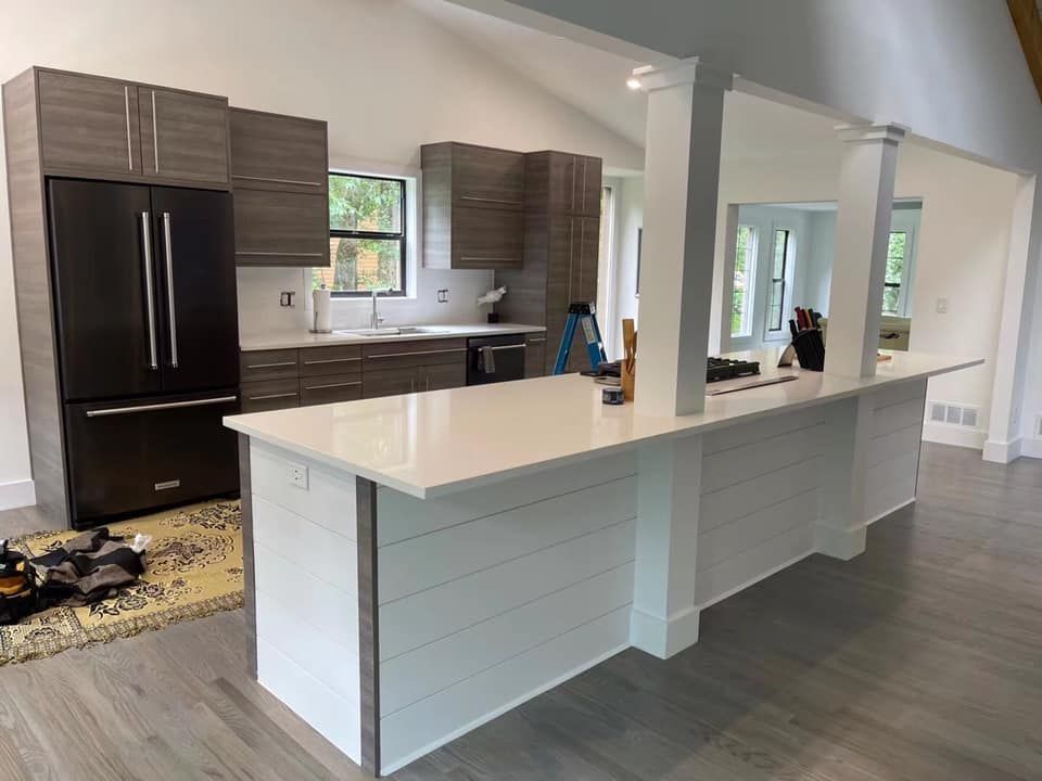 A kitchen with a large island and a refrigerator.