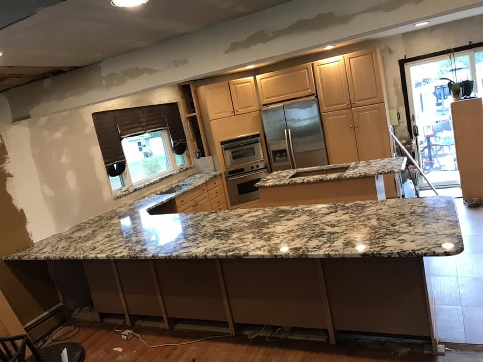 A kitchen with granite counter tops and stainless steel appliances.