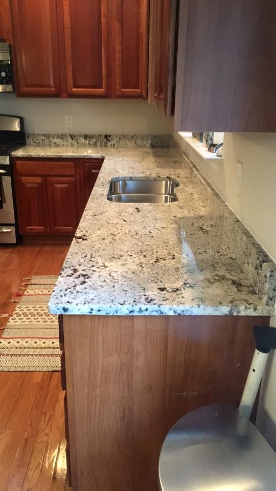 A kitchen with granite counter tops and stainless steel appliances.