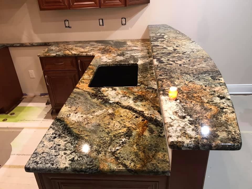 A kitchen with a granite counter top and a sink.