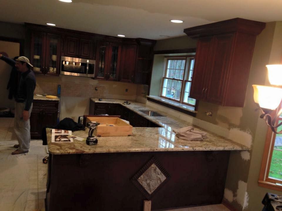 A man is standing in a kitchen with a large island.