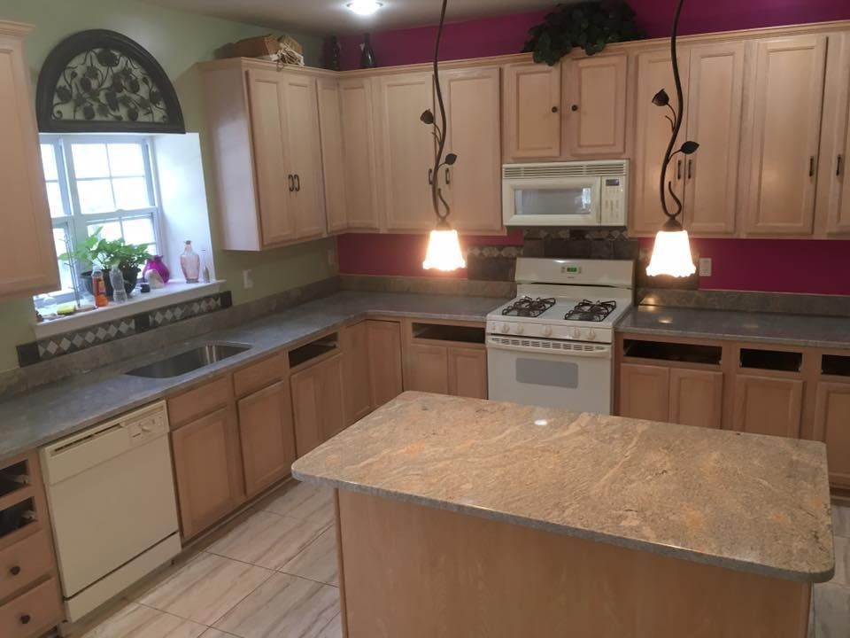 A kitchen with a stove a sink and a microwave