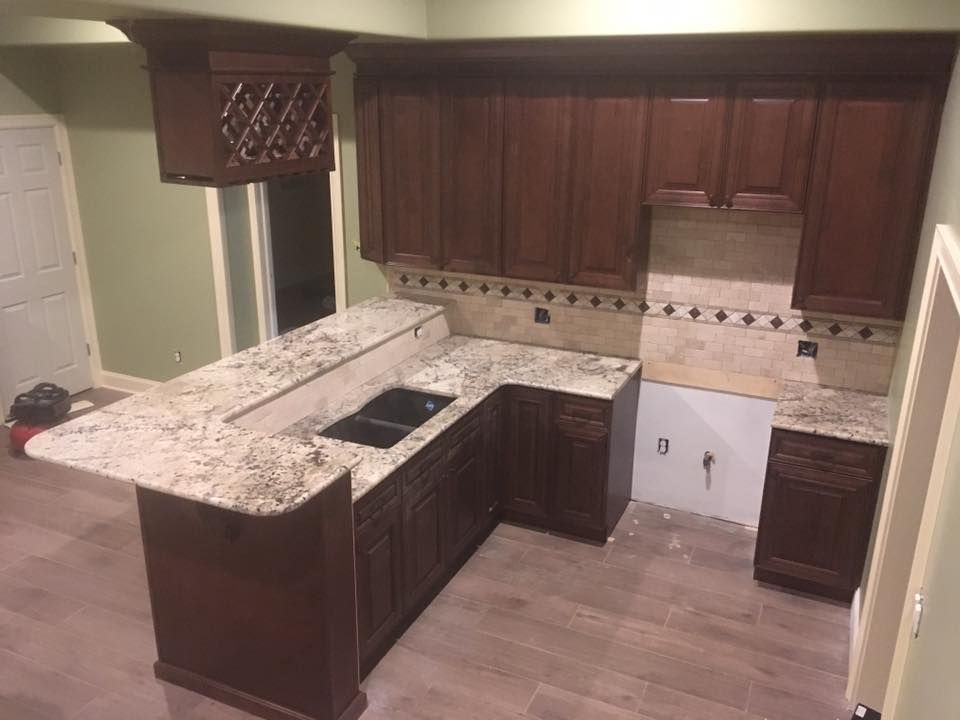 A kitchen with wooden cabinets and granite counter tops.