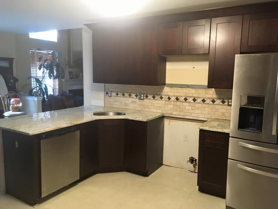 A kitchen with stainless steel appliances and wooden cabinets.