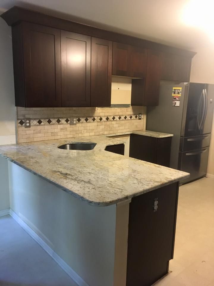 A kitchen with a refrigerator , sink , and dishwasher.