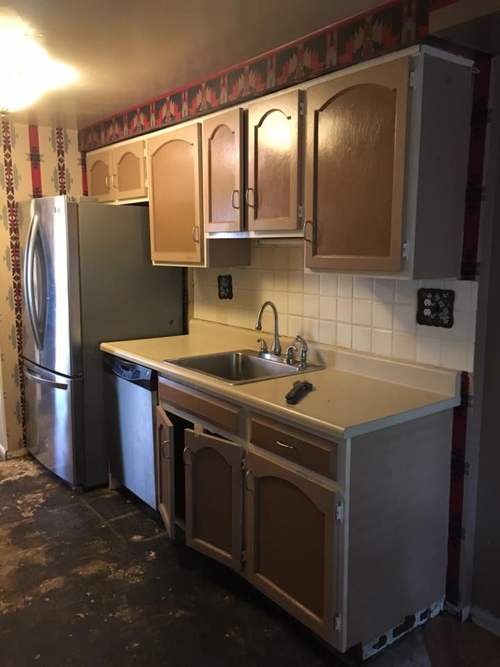 A kitchen with a sink , refrigerator and dishwasher