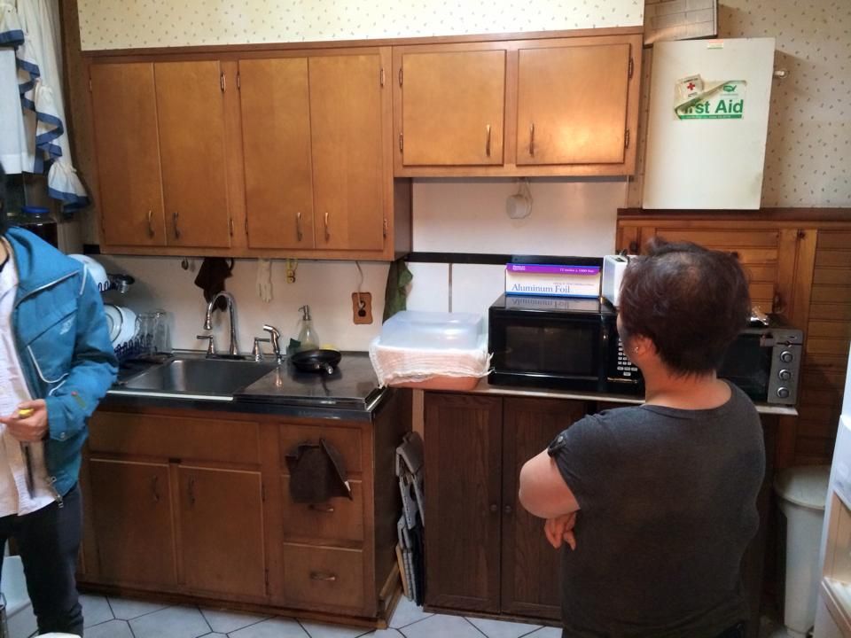 A woman is standing in a kitchen next to a fridge that says ' dry aid ' on it