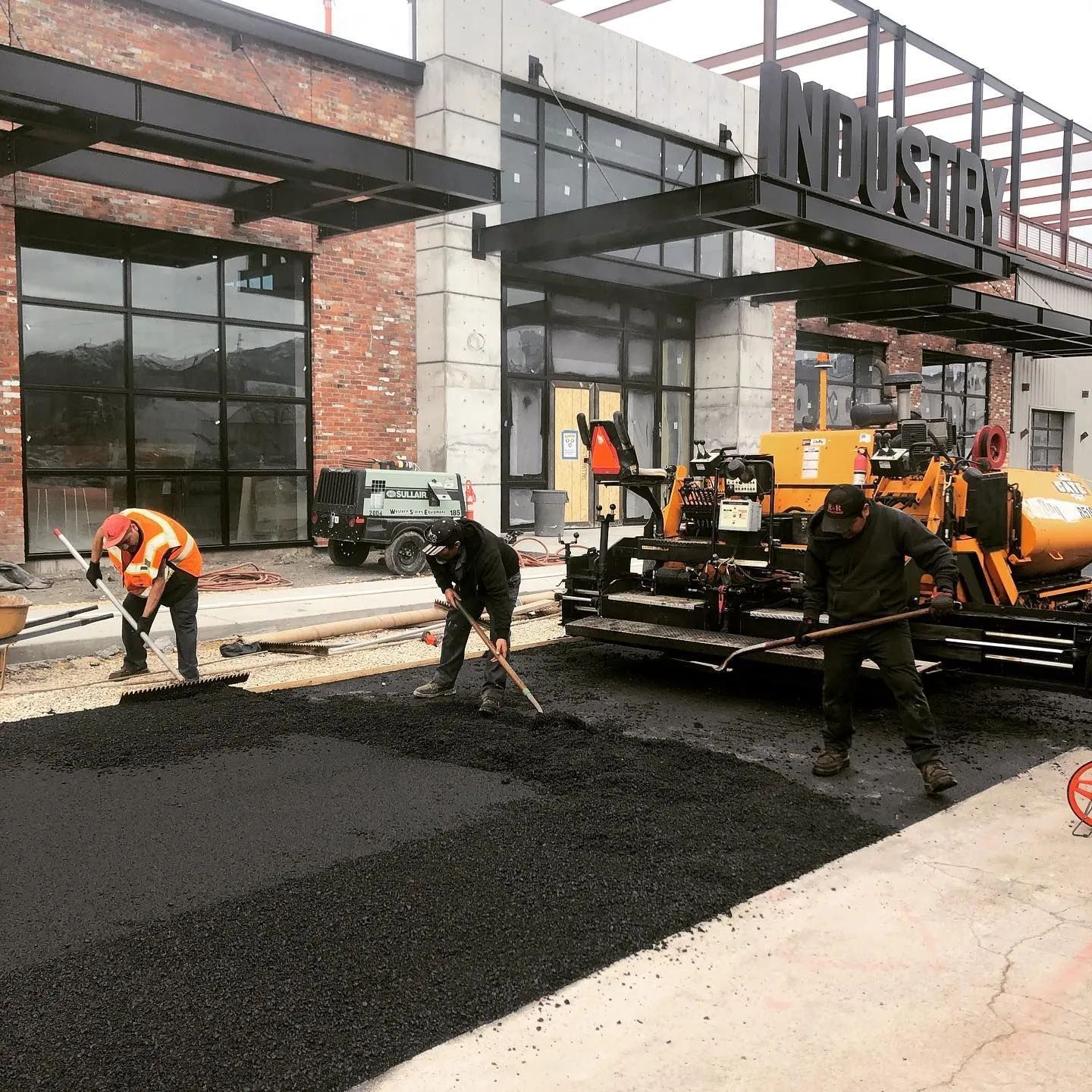 Construction workers paving a road in front of the 