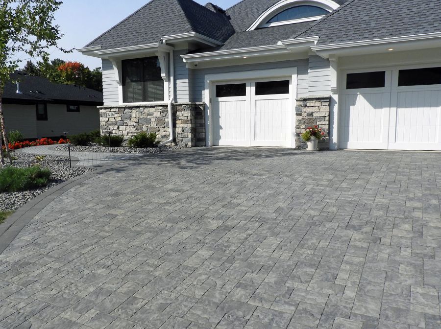 A house with two garage doors and a brick driveway