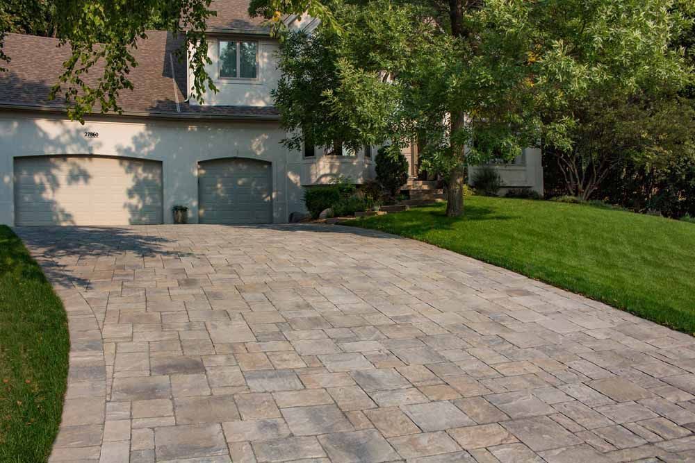 a driveway leading to a house with two garage doors