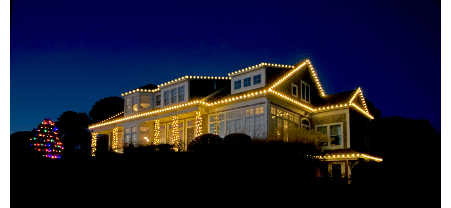 House decorated with Christmas lights at night.
